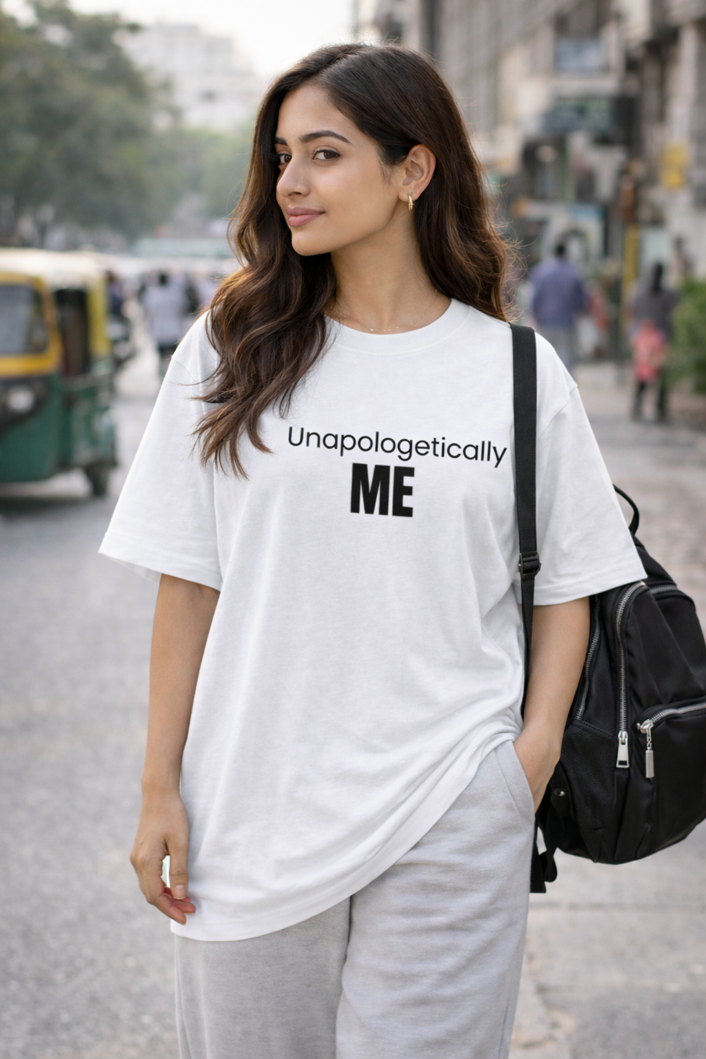 Woman wearing a white t-shirt with 'Unapologetically ME' text on a street.